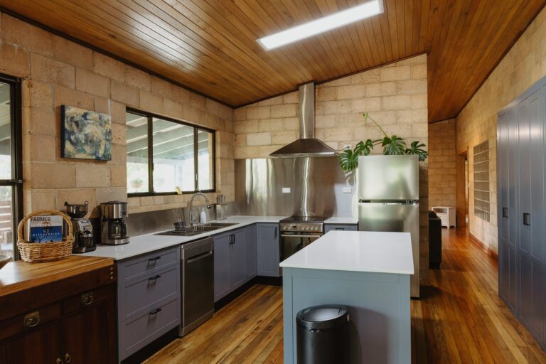 Kitchen in a brick home with grey benchtops and an exhaust fan